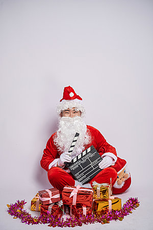 圣诞老人坐着拿场记板摄影图
