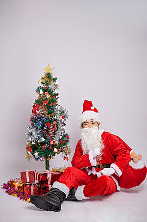 圣诞老人伸腿坐姿人物摄影图