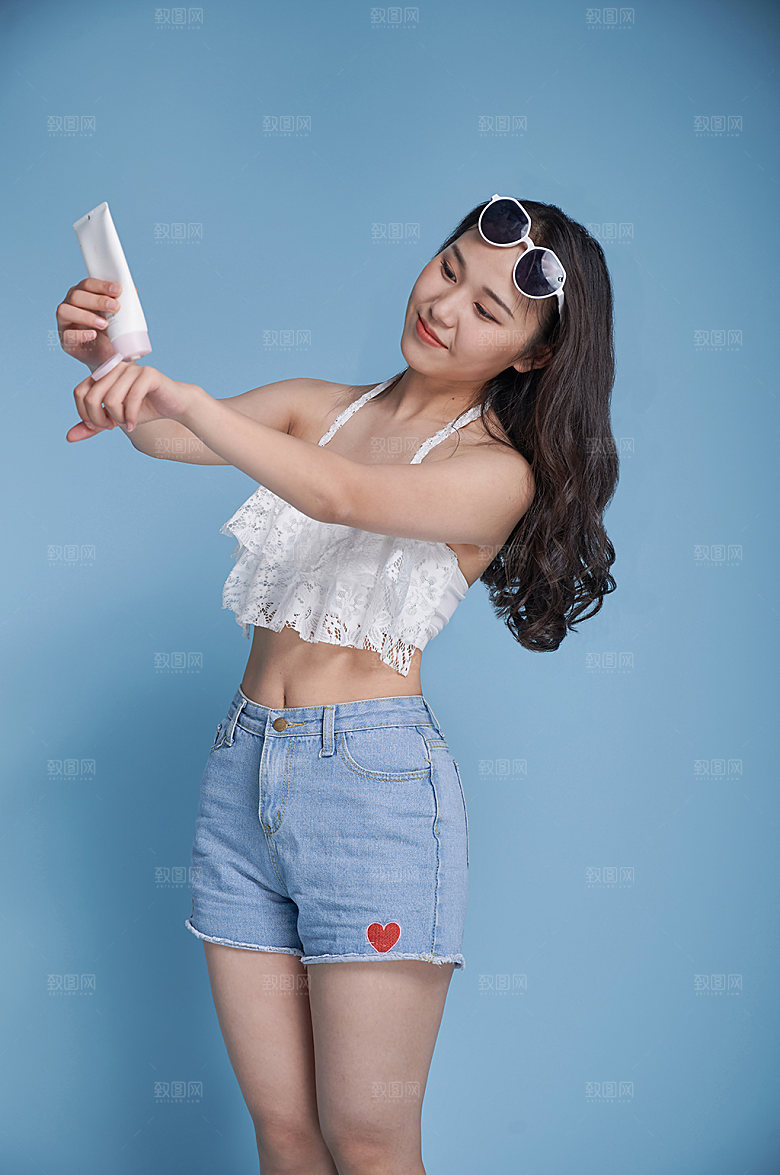 沙滩女生涂防晒精修人物摄影图