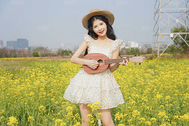 小清新少女油菜花弹吉他摄影图